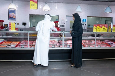 Emirati Man and Woman at Supermarket Butcher Counter