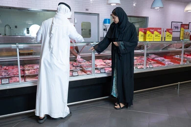 زوجين إماراتيين يتسوقان في قسم اللحوم بالسوبر ماركت