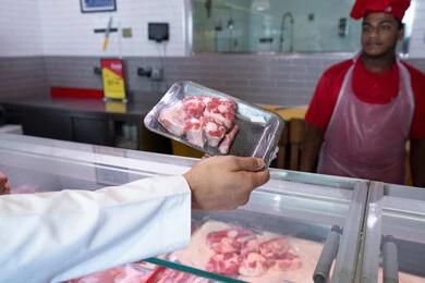 رجل إماراتي يشتري اللحم الطازج في قسم اللحوم