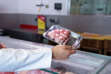 Emirati Man Holding Raw Meat Tray in Local Supermarket