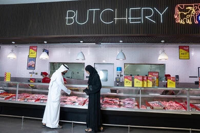 Emirati Couple Shopping at Supermarket Butchery Counter