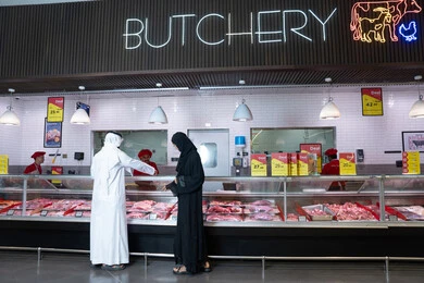 رجل وامرأة بالزي الإماراتي في قسم الملحمة بالسوق