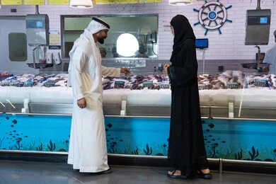 Emirati Couple Shopping for Fresh Fish in UAE Supermarket