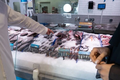 رجل إماراتي يشتري الأسماك الطازجة من السوبر ماركت