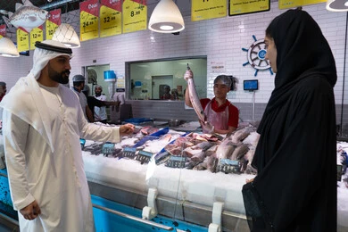 Emirati Couple Shopping for Fresh Fish in Supermarket