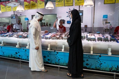 زوجان إماراتيان يتسوقان في قسم الأسماك بالمتجر