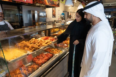 Emirati Couple at Restaurant Food Display Counter Emirati Couple at Restaurant Food Display Counter