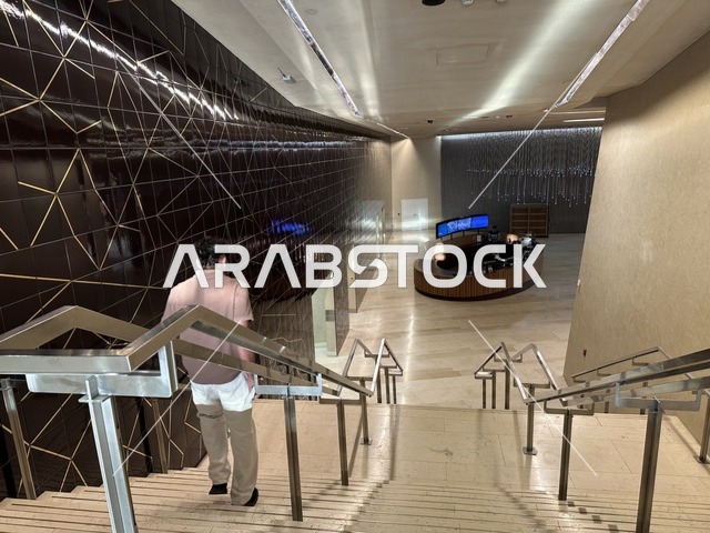 A man is using the stairs of the Ithra Center, October 5, 2025, a place for readers and lovers of knowledge, books, and learning, the largest public library in Saudi Arabia, the King Abdulaziz Center for World Culture (Ithra) in Dhahran, Saudi Arabia, with books, novels, and stories arranged on the shelves.
