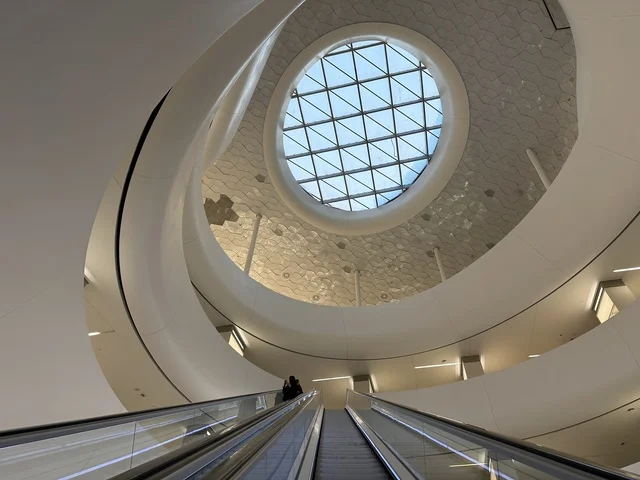 An interior image of a woman ascending the stairs of the Ithra Center, October 5, 2025, a place for readers and lovers of knowledge, books, and learning, the largest public library in Saudi Arabia, the King Abdulaziz Center for World Culture (Ithra) in Dhahran, Saudi Arabia, with books, novels, and stories arranged on the shelves.