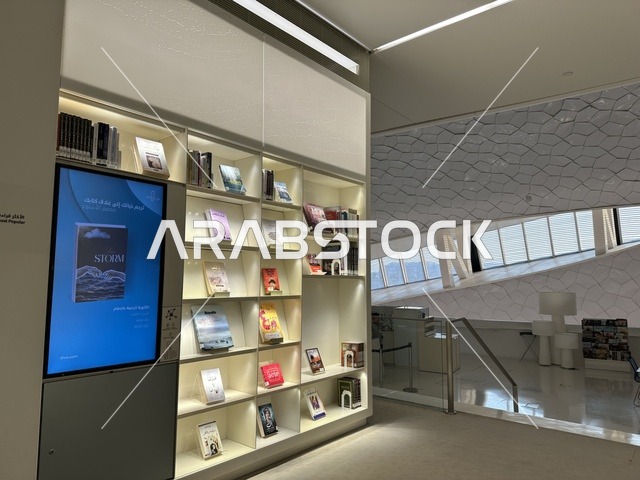 منطقة عرض داخلية واسعة ومضاءة، 5 أكتوبر 2025، مكان للقراء ومحبي العلم والكتب والمعرفة، أكبر المكتبات العامة في السعوديه، مركز الملك عبد العزيز الثقافي العالمي (إثراء) في مدينة الظهران في المملكة العربية السعودية, كتب و روايات وقصص مرتبة في الرفوف.