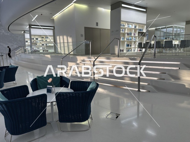 منطقة جلوس داخلية حديثة وأنيقة، 5 أكتوبر 2025، مكان للقراء ومحبي العلم والكتب والمعرفة، أكبر المكتبات العامة في السعوديه، مركز الملك عبد العزيز الثقافي العالمي (إثراء) في مدينة الظهران في المملكة العربية السعودية, كتب و روايات وقصص مرتبة في الرفوف.