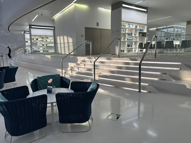 منطقة جلوس داخلية حديثة وأنيقة، 5 أكتوبر 2025، مكان للقراء ومحبي العلم والكتب والمعرفة، أكبر المكتبات العامة في السعوديه، مركز الملك عبد العزيز الثقافي العالمي (إثراء) في مدينة الظهران في المملكة العربية السعودية, كتب و روايات وقصص مرتبة في الرفوف.