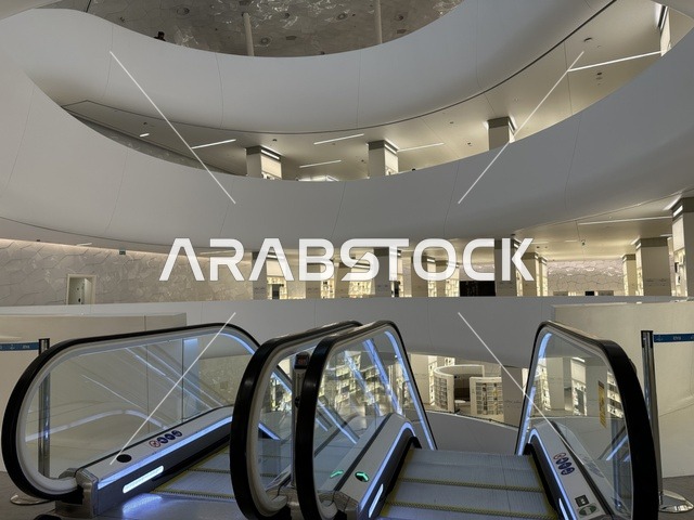 سلم متحرك للتنقل بين الادوار، 5 أكتوبر 2025، مكان للقراء ومحبي العلم والكتب والمعرفة، أكبر المكتبات العامة في السعوديه، مركز الملك عبد العزيز الثقافي العالمي (إثراء) في مدينة الظهران في المملكة العربية السعودية, كتب و روايات وقصص مرتبة في الرفوف.