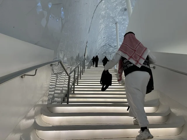 زوار المكتبة يصعدون سلم في المكان، 5 أكتوبر 2025، مكان للقراء ومحبي العلم والكتب والمعرفة، أكبر المكتبات العامة في السعوديه، مركز الملك عبد العزيز الثقافي العالمي (إثراء) في مدينة الظهران في المملكة العربية السعودية, كتب و روايات وقصص مرتبة في الرفوف.