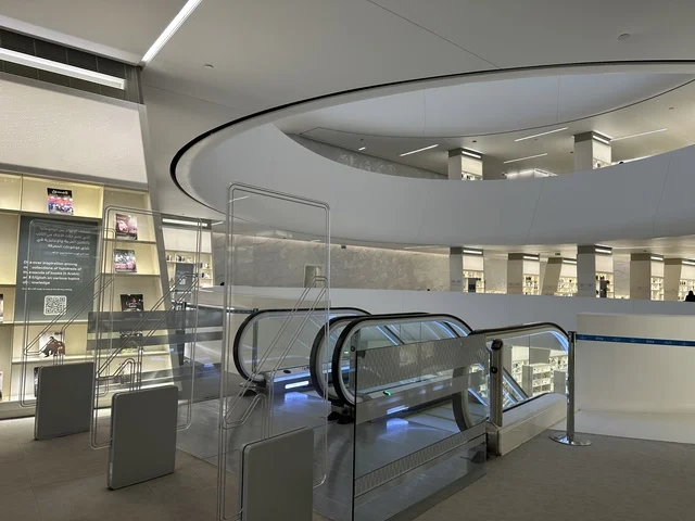 سلم متحرك للتنقل بين الادوار، 5 أكتوبر 2025، مكان للقراء ومحبي العلم والكتب والمعرفة، أكبر المكتبات العامة في السعوديه، مركز الملك عبد العزيز الثقافي العالمي (إثراء) في مدينة الظهران في المملكة العربية السعودية, كتب و روايات وقصص مرتبة في الرفوف.