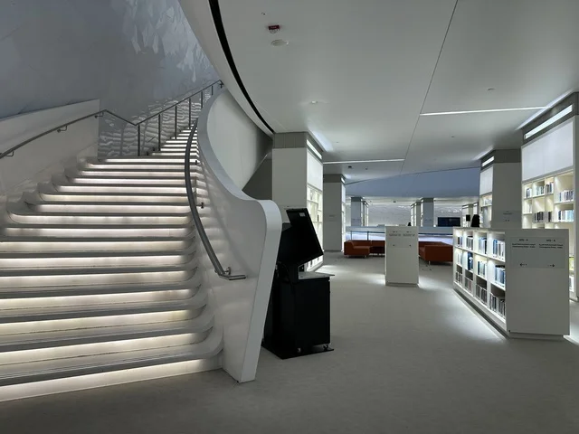 A staircase with a modern design inside the library, October 5, 2025, a place for readers and lovers of knowledge, books, and learning, the largest public library in Saudi Arabia, the King Abdulaziz Center for World Culture (Ithra) in Dhahran, Saudi Arabia, with books, novels, and stories arranged on the shelves.