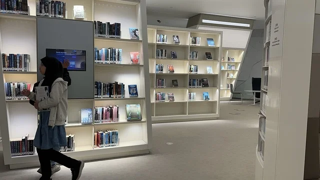 طفلين يقومان بتصفح الكتب في مكتبة،منارة ثقافية و معالم سياحية مشهورة, مكان للقراء ومحبي العلم والكتب والمعرفة، أكبر المكتبات العامة في السعوديه،  5 أكتوبر 2025، مركز الملك عبد العزيز الثقافي العالمي (إثراء) في مدينة الظهران في المملكة العربية السعودية.