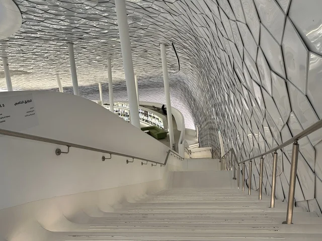 استخدام السلالم والادراج داخل المكتبة، منارة ثقافية و معالم سياحية مشهورة, مكان للقراء ومحبي العلم والكتب والمعرفة، أكبر المكتبات العامة في السعوديه،  5 أكتوبر 2025، مركز الملك عبد العزيز الثقافي العالمي (إثراء) في مدينة الظهران في المملكة العربية السعودية.