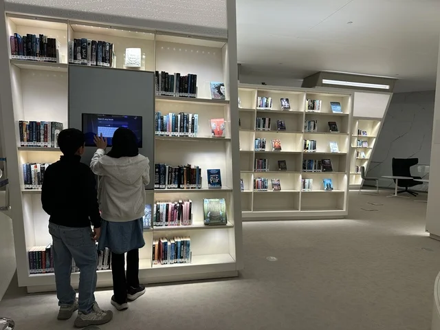 Two children are browsing books in a library, a cultural beacon and famous tourist attractions, a place for readers and lovers of science, books, and knowledge, the largest public library in Saudi Arabia, October 5, 2025, King Abdulaziz Center for World Culture (Ithra) in Dhahran, Saudi Arabia.