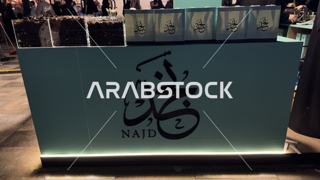 كشك يحمل كلمة نجد بخط عربي، فعالية تكوة في جدة في المملكة العربية السعودية  17 يناير 2026،  تجربة شتوية تجمع بين الترفيه، التسوق، والمطاعم، تشمل الفعالية عرض موسيقي حي وفرق استعراضية متجولة،  مخصصة لجميع أفراد العائلة