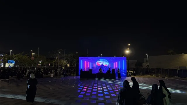 مسرح مضاء بأضواء زرقاء ووردية ، فعالية تكوة في جدة في المملكة العربية السعودية  17 يناير 2026،  تجربة شتوية تجمع بين الترفيه، التسوق، والمطاعم، تشمل الفعالية عرض موسيقي حي وفرق استعراضية متجولة،  مخصصة لجميع أفراد العائلة