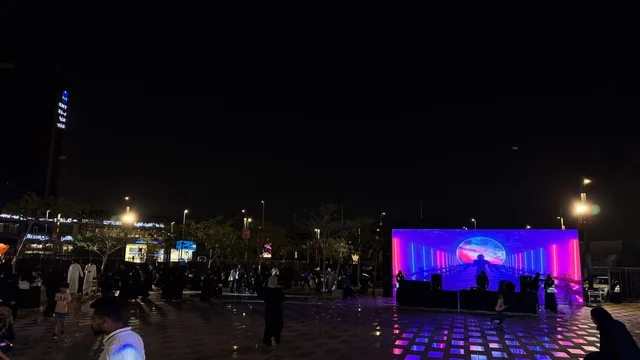 مسرح مضاء بأضواء زرقاء ووردية ، فعالية تكوة في جدة في المملكة العربية السعودية  17 يناير 2026،  تجربة شتوية تجمع بين الترفيه، التسوق، والمطاعم، تشمل الفعالية عرض موسيقي حي وفرق استعراضية متجولة،  مخصصة لجميع أفراد العائلة