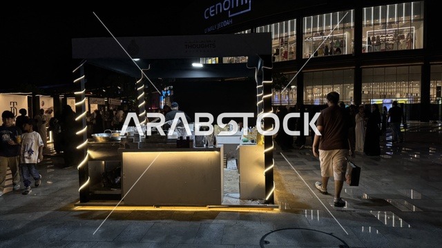 مبنى في الخلفية مضاء بنوافذ كبيرة، فعالية تكوة في جدة في المملكة العربية السعودية  17 يناير 2026،  تجربة شتوية تجمع بين الترفيه، التسوق، والمطاعم، تشمل الفعالية عرض موسيقي حي وفرق استعراضية متجولة،  مخصصة لجميع أفراد العائلة