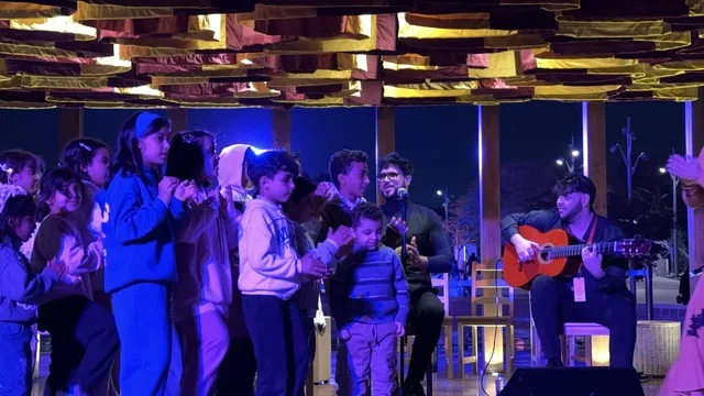 تفاعل الاولاد مع فنان يقدم عرض موسيقي في فعالية شارع أسبانيا في مركز الملك عبدالعزيز الثقافي العالمي "إثراء" بمدينة الظهران في المنطقة الشرقية، المملكة العربية السعودية، يوم 11 من أكتوبر 2025، تجربة ثقافية وترفيهية ، رقصات فلامنكو وفعاليات تفاعلية، مطاعم ومقاهي بطابع اسباني، أنشطة مناسبة العائلات والأطفال، أجواء احتفالية نابضة بالحياة.