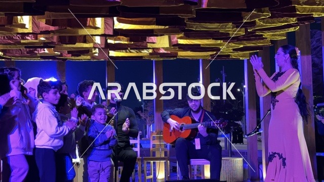 تفاعل الاولاد مع فنان يقدم عرض موسيقي في فعالية شارع أسبانيا في مركز الملك عبدالعزيز الثقافي العالمي "إثراء" بمدينة الظهران في المنطقة الشرقية، المملكة العربية السعودية، يوم 11 من أكتوبر 2025، تجربة ثقافية وترفيهية ، رقصات فلامنكو وفعاليات تفاعلية، مطاعم ومقاهي بطابع اسباني، أنشطة مناسبة العائلات والأطفال، أجواء احتفالية نابضة بالحياة.