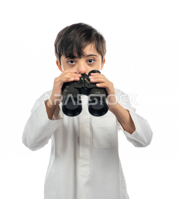 Portrait of a Saudi Arabian Gulf boy with Down Syndrome looking through the lens, exploration and adventure, scouting team, attention to the abilities of people with special needs, capacity development, recreational activities for people of determination,