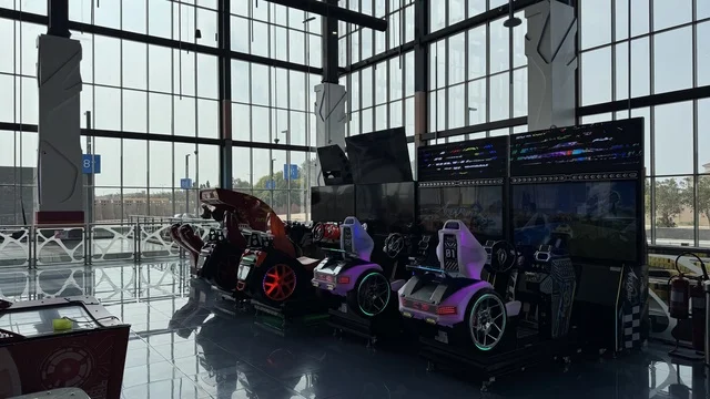 Activities and entertainment games at the Yo Walk complex in Jeddah, Saudi Arabia, an open walkway with a modern design, international and local restaurants and cafes, a comprehensive urban destination for walking, entertainment, and shopping, diverse brand names, the exterior design of the Sinomi Mall building, outdoor seating and social spaces, vibrant family and youth atmosphere.