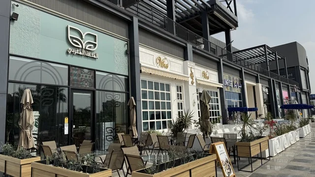 International and local restaurants and cafes at the U Walk complex in Jeddah, Saudi Arabia, February 15, 2024, an open walkway with a modern design, the exterior design of the Sinomi Mall building, a comprehensive urban destination for walking, entertainment, and shopping, outdoor seating and social spaces, a vibrant family and youth atmosphere.