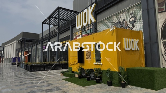 International and local restaurants and cafes at the U Walk complex in Jeddah, Saudi Arabia, February 15, 2024, an open walkway with a modern design, the exterior design of the Sinomi Mall building, a comprehensive urban destination for walking, entertainment, and shopping, outdoor seating and social spaces, a vibrant family and youth atmosphere.