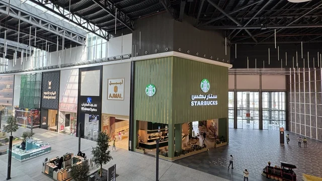 A brand in the U Walk complex in Jeddah, Saudi Arabia, February 15, 2024, an open walkway with a modern design, international and local restaurants and cafes, the exterior design of the Sinomi Mall building, a comprehensive urban destination for walking, entertainment, and shopping, outdoor seating and social spaces, a vibrant family and youth atmosphere. A brand in the U Walk complex in Jeddah, Saudi Arabia, February 15, 2024, an open walkway with a modern design, international and local restau