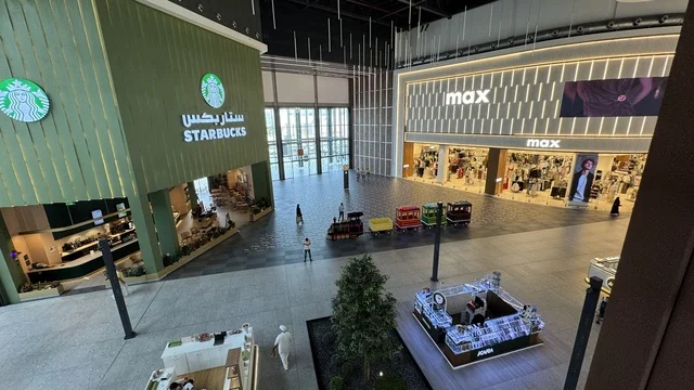 A brand in the U Walk complex in Jeddah, Saudi Arabia, February 15, 2024, an open walkway with a modern design, international and local restaurants and cafes, the exterior design of the Sinomi Mall building, a comprehensive urban destination for walking, entertainment, and shopping, outdoor seating and social spaces, a vibrant family and youth atmosphere. A brand in the U Walk complex in Jeddah, Saudi Arabia, February 15, 2024, an open walkway with a modern design, international and local restau