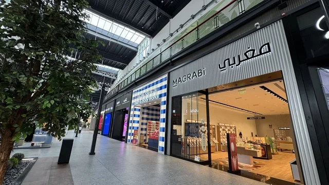 Global and local retail stores at the U Walk complex in Jeddah, Saudi Arabia, February 15, 2024, an open walkway with a modern design, restaurants and cafes, a comprehensive urban destination for walking, entertainment, and shopping, outdoor seating and social spaces, a vibrant family and youth atmosphere.