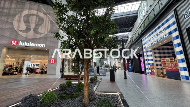 Global and local retail stores at the U Walk complex in Jeddah, Saudi Arabia, February 15, 2024, an open walkway with a modern design, restaurants and cafes, a comprehensive urban destination for walking, entertainment, and shopping, outdoor seating and social spaces, a vibrant family and youth atmosphere.