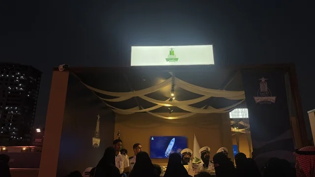 مكان بديكور تقليدية وبعض الأشخاص يرتدون ملابس تقليدية، مهرجان السفن الخشبية على شاطئ الحمراء بجدة في المملكة العربية السعودية 12 إلى 16 يناير 2026، عروض لمراحل بناء السفن التقليدية والأدوات والمواد المستخدمة،  التراث البحري، الأنشطة التفاعلية والعروض الثقافية