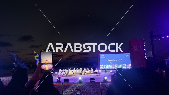 شاشة الكبيرة في الخلفية ، مهرجان السفن الخشبية على شاطئ الحمراء بجدة في المملكة العربية السعودية 12 إلى 16 يناير 2026، عروض لمراحل بناء السفن التقليدية والأدوات والمواد المستخدمة،  التراث البحري والهوية الساحلية، الأنشطة التفاعلية والعروض الثقافية