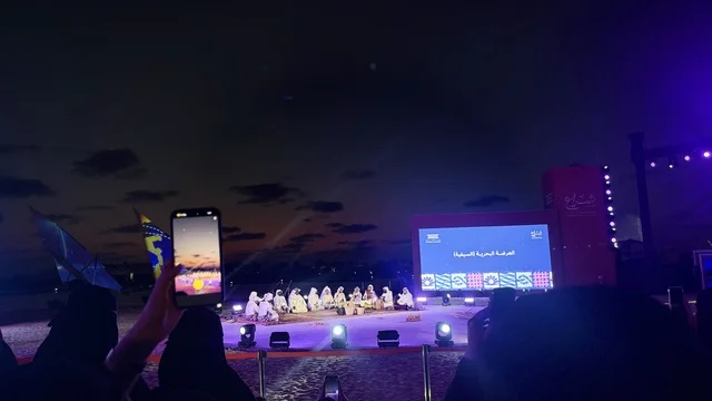 شاشة الكبيرة في الخلفية ، مهرجان السفن الخشبية على شاطئ الحمراء بجدة في المملكة العربية السعودية 12 إلى 16 يناير 2026، عروض لمراحل بناء السفن التقليدية والأدوات والمواد المستخدمة،  التراث البحري والهوية الساحلية، الأنشطة التفاعلية والعروض الثقافية