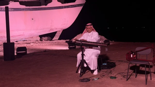 شخص يرتدي الزي التقليدي ويعزف على آلة موسيقية، عروض لمراحل بناء السفن التقليدية والأدوات والمواد المستخدمة، مهرجان السفن الخشبية على شاطئ الحمراء بجدة في المملكة العربية السعودية 12 إلى 16 يناير 2026، التراث البحري، الأنشطة التفاعلية والعروض الثقافية