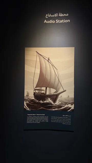 A sign titled Listening Station, displays of the stages of traditional shipbuilding and the tools and materials used, Wooden Ships Festival on the Al-Hamra Beach in Jeddah, Saudi Arabia from January 12 to 16, 2026, maritime heritage, interactive activities, and cultural performances.