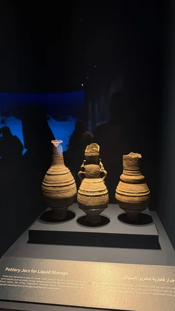 A jar displayed in a museum environment, exhibitions of the stages of traditional shipbuilding and the tools and materials used, the wooden ships festival on the Al-Hamra beach in Jeddah, Saudi Arabia from January 12 to 16, 2026, maritime heritage, interactive activities, and cultural performances.