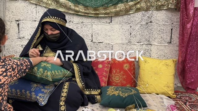 Henna painting for children, a shopping experience between the fragrance of time and the authenticity of the place, the "Life of the Past" event in the Eastern Province, Dammam, during January 2026 in the Kingdom of Saudi Arabia, features of the past and old life through a heritage atmosphere.