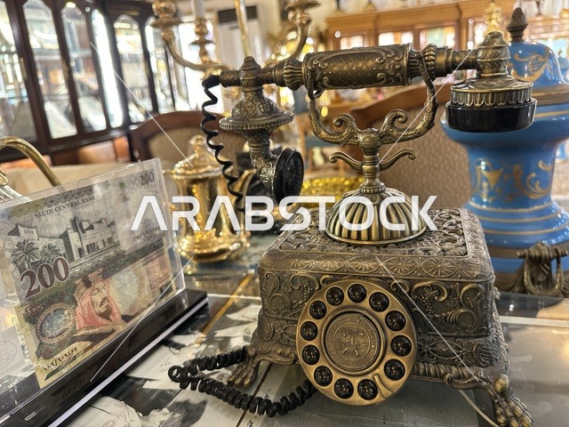 هاتف دوار مزخرف من النحاس بمتحف الفلوة والجوهرة في حي النزهة بمدينة الدمام، المنطقة الشرقية، المملكة العربية السعودية، يوم 21 من فبراير 2018 ، وجهة تعليمية وسياحية مميزة ،  التراث السعودي، السيارات الكلاسيكية  ، معلم تراثي وثقافي يعرض تاريخ الأزياء والحلي التقليدية ، توثيق للحرف اليدوية والهوية السعودية، الفن الإسلامي