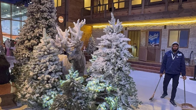 عامل يقوم بالتنظيف في تجربة كورفشيفل فى منطقة بوليفارد وورلد بالرياض، المملكة العربية السعودية يوم 25 من نوفمبر 2025، ديكور ثلجي ومشهد جبلي ،أجواء فاخرة تجمع الترفيه والاستجمام، فعالية ترفيهية شتوية مستوحاة من أجواء منتجعات التزلج الأوروبية،  مطاعم ومقاهي بطابع شتوي، أنشطة تفاعلية ممتعه