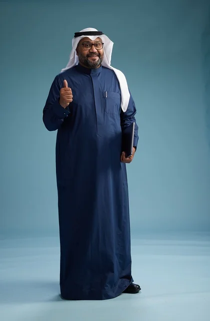 بورتريه لرجل سعودي بثوب أزرق وغترة بيضاء يستخدم الكمبيوتر المحمول, خلفيه زرقاء