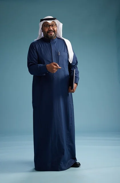 بورتريه لرجل سعودي بثوب أزرق وغترة بيضاء يستخدم الكمبيوتر المحمول, خلفيه زرقاء