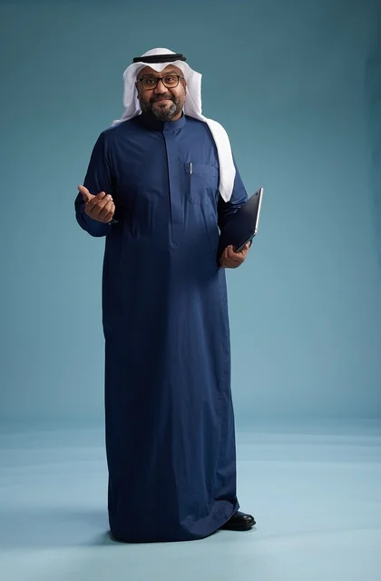 بورتريه لرجل سعودي بثوب أزرق وغترة بيضاء يستخدم الكمبيوتر المحمول, خلفيه زرقاء