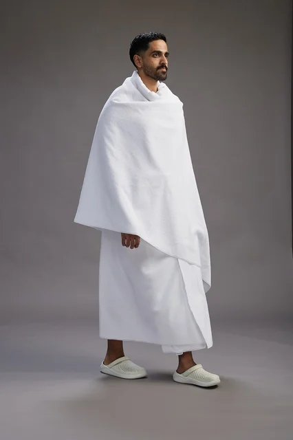 A portrait of an Arab Saudi Gulf man wearing Ihram clothing to perform the rituals of Hajj, worship, and drawing closer to God, Hajj and Umrah in Mecca, full-body, gray background. A portrait of an Arab Saudi Gulf man wearing Ihram clothing to perform the rituals of Hajj, worship, and drawing closer to God, Hajj and Umrah in Mecca, full-body, gray background.
